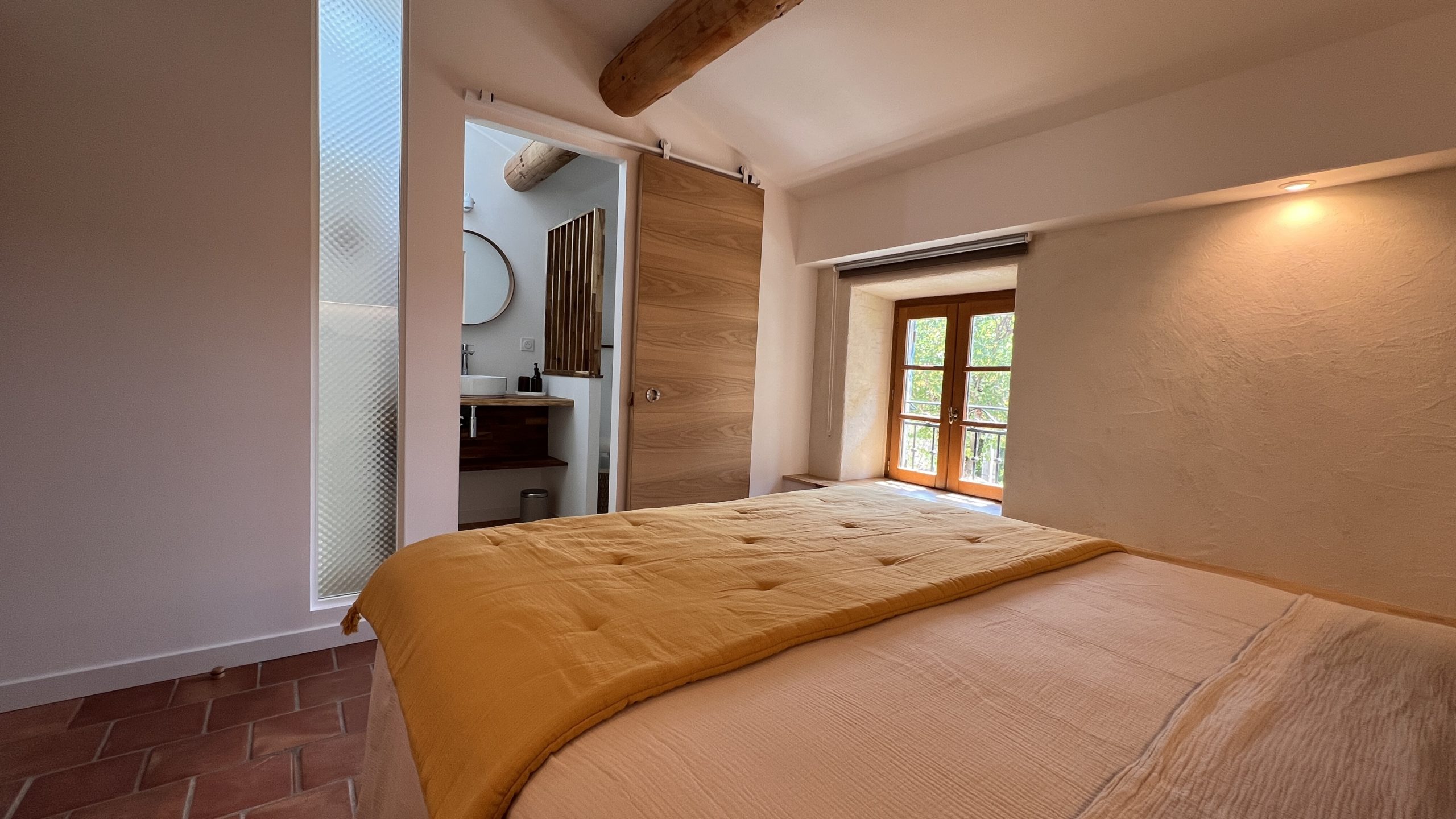 Chambre double du gîte La Grange avec salle d’eau privative et sol en tomettes