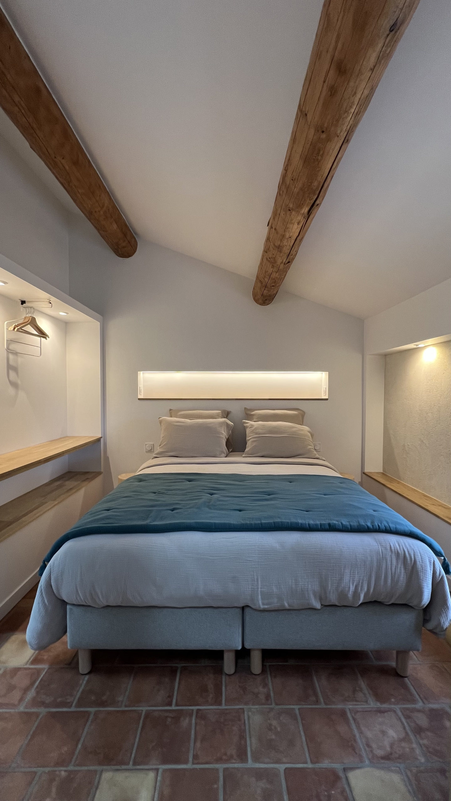Chambre double du gîte La Grange avec poutres apparentes et sol en tomettes