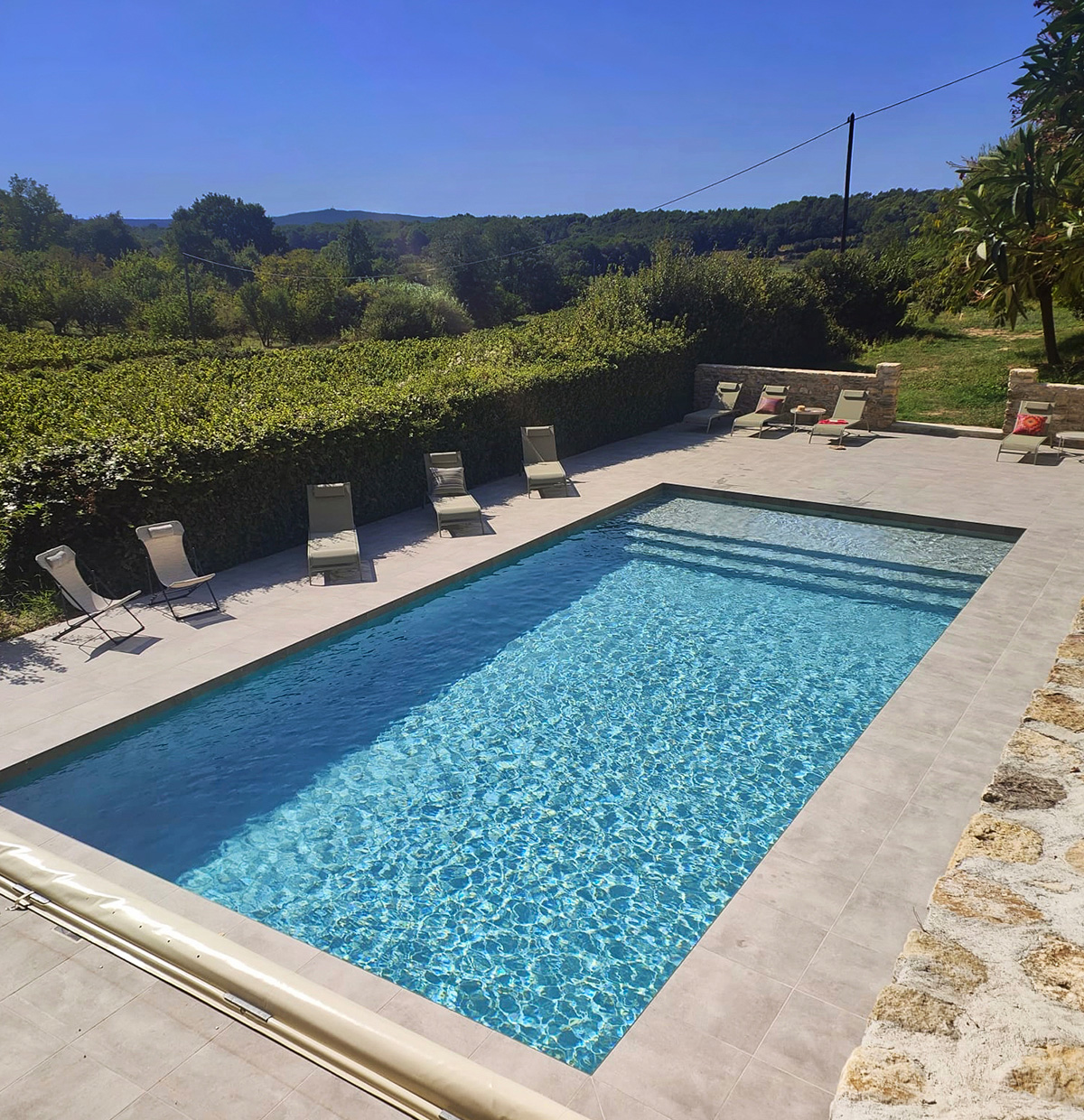 Piscine extérieure de La Petite Blanchardière à Sabran, entourée de transats, avec vue sur les vignes et la campagne